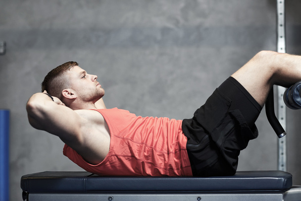 young man making abdominal exercises in gym - Photo, Image