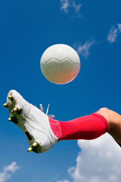 Jugador de fútbol rebotando la pelota
 - Foto, Imagen