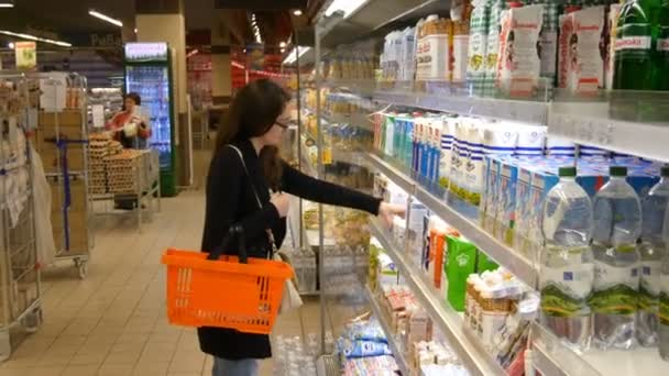 Mujer joven comprando productos lácteos o refrigerados en el supermercado
 - Metraje, vídeo