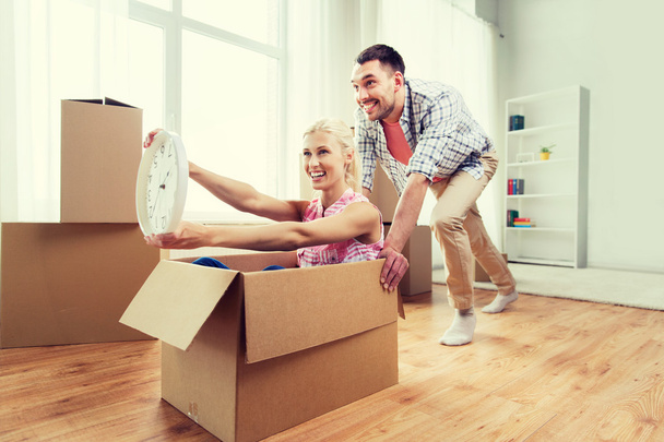 pareja con cajas de cartón que se divierten en un nuevo hogar
 - Foto, Imagen