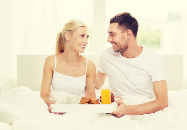 happy couple having breakfast in bed at home - Fotoğraf, Görsel