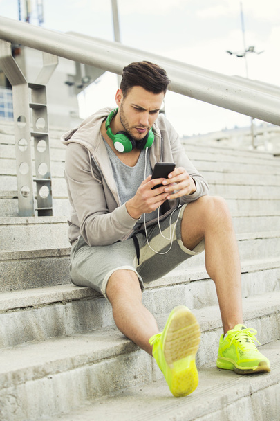 Young man outdoors texting and looking worried - Photo, Image