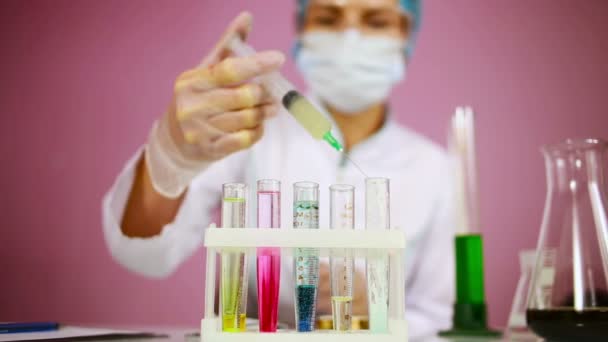 Ženské chemik porovnávání zkumavek s chemikáliemi. ochranné brýle - Záběry, video
