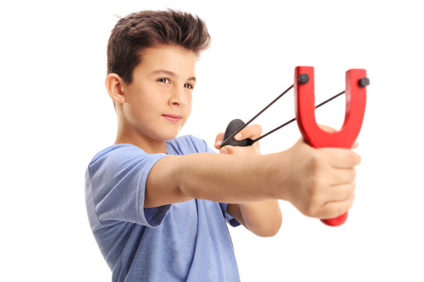 boy firing a rock from a slingshot  - Zdjęcie, obraz