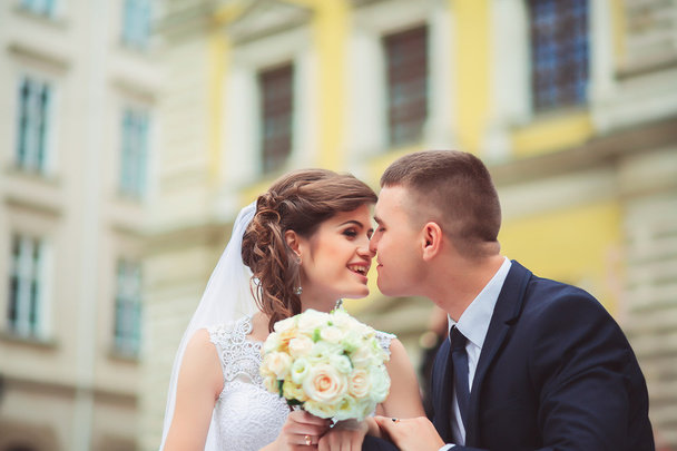 gorgeous wedding couple enjoys a Sunny day in the old town with architecture - Foto, imagen