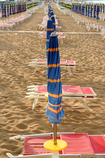 Blauer geschlossener Sonnenschirm nach Sturm am Strand - Foto, Bild