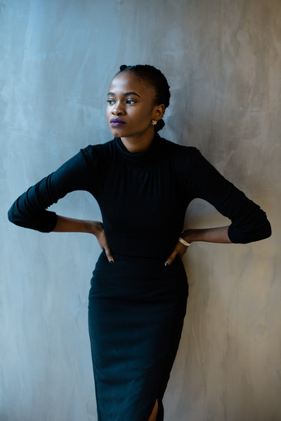 Picture of a sexy young black woman posing with her hands on the waist, isolated gray background - Fotó, kép