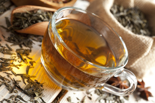 Copa de té y mezcla de hojas de té surtidos en la mesa de madera
 - Foto, imagen