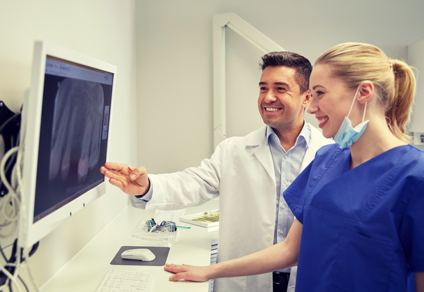 dentists with x-ray on monitor at dental clinic - Фото, изображение