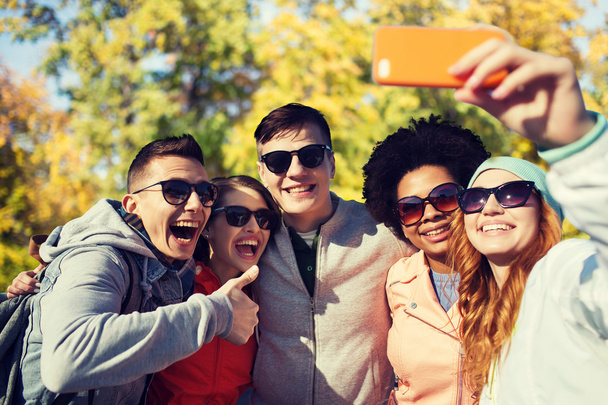 smiling friends taking selfie with smartphone - Фото, зображення