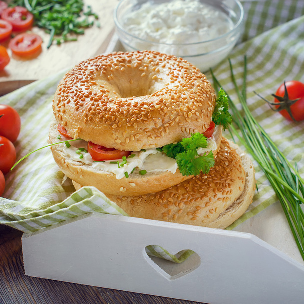 Bagels wtih cream cheese, tomatoes and chives for healthy snack, - 写真・画像
