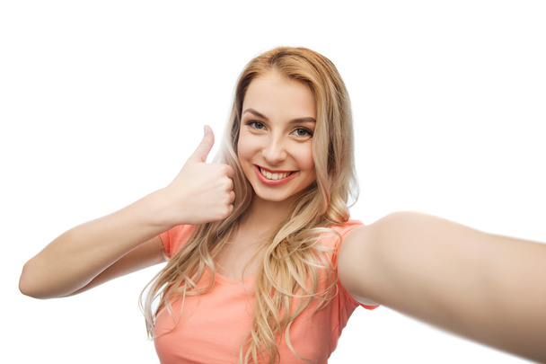 mujer feliz tomando selfie y mostrando pulgares hacia arriba
 - Foto, imagen