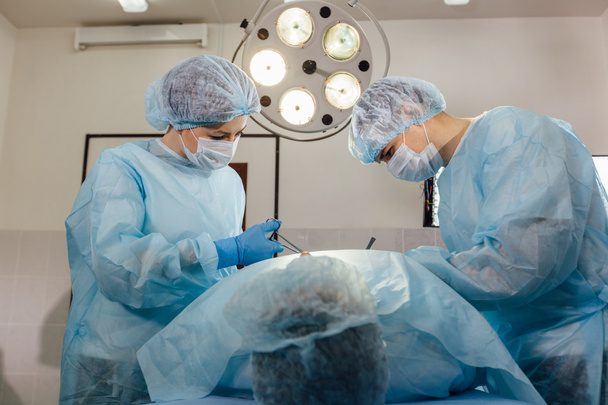 Chirurgen-Team arbeitet mit Überwachung des Patienten im Operationssaal. - Foto, Bild