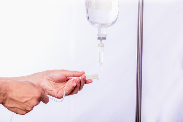 Close up hand adjustment saline IV drip for patient in hospital with copy space - Foto, afbeelding