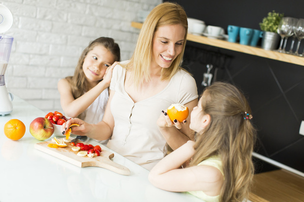 Woman and two girls in the kitchen - Foto, Imagen