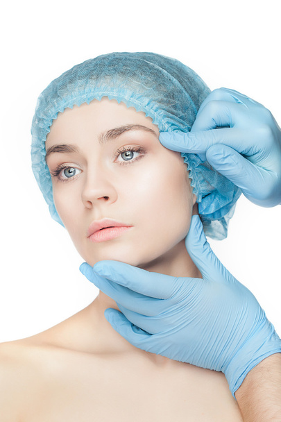 Plastic surgery concept. Doctor hands in gloves touching woman face - Foto, imagen