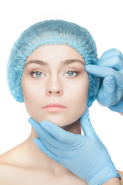Plastic surgery concept. Doctor hands in gloves touching woman face - Фото, зображення