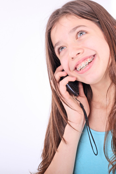 Attractive teen girl talking on phone over white - Foto, Imagen