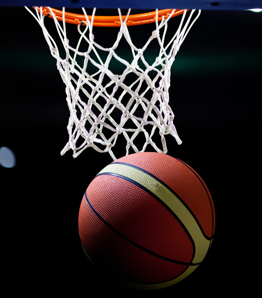 basketbal gaat door de ring in een sportarena - Foto, afbeelding