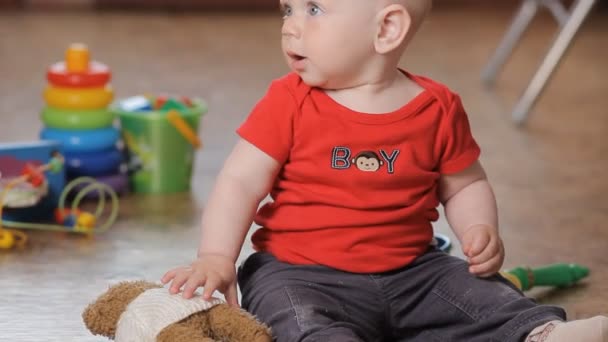 Adorable little boy playing with teddy bear, smiling. - Video