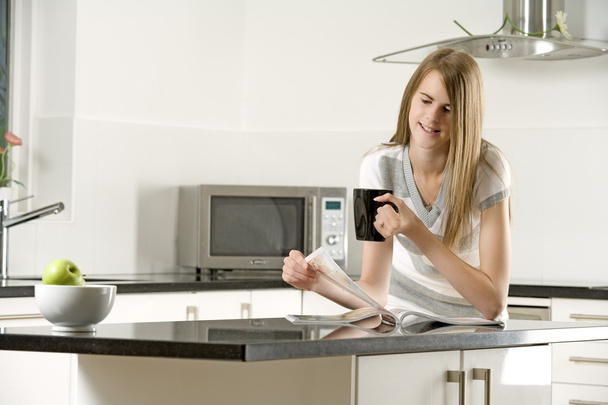 jonge vrouw ontspannen in haar keuken - Foto, afbeelding