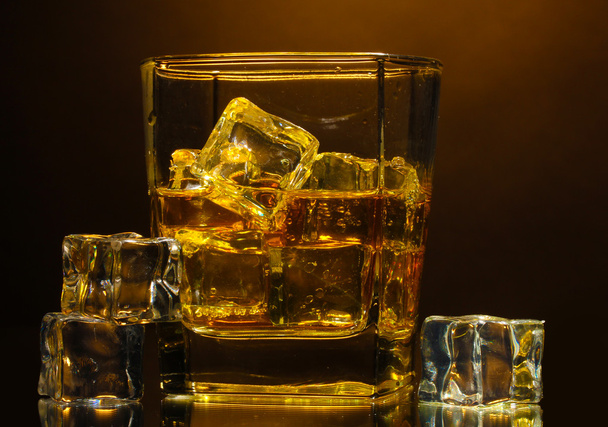 Glass of scotch whiskey and ice on brown background - Foto, Imagem