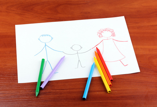 Children's drawing of family and pencils on wooden background - Фото, зображення