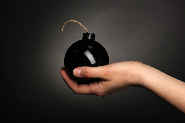 Cartoon style bomb in hand on black background - Photo, image