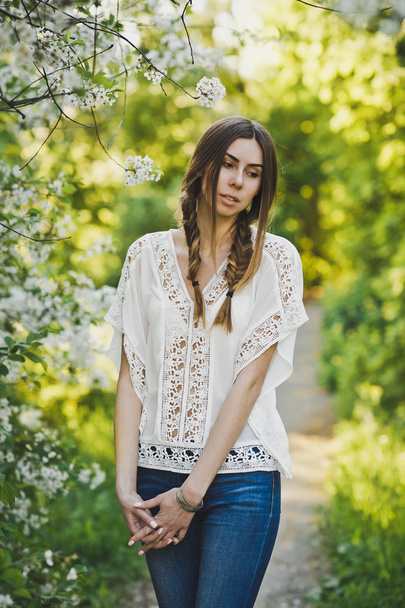 Girl in white blouse walking through the garden 6104. - Foto, Imagen