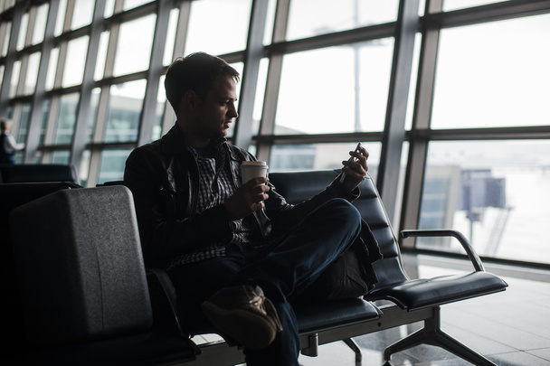 man waiting at airport lounge texting with his smart phone - Photo, Image