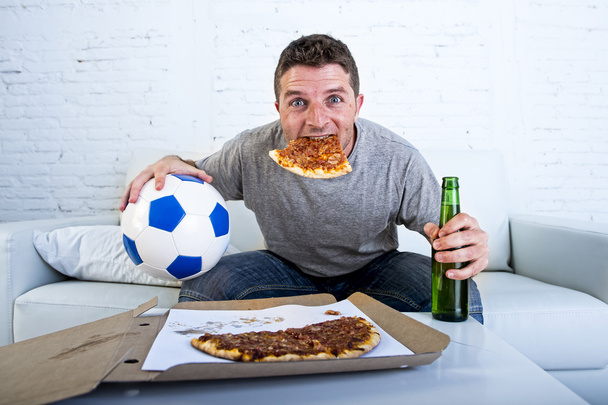 man celebrating goal at home couch watching football game on television - Photo, image