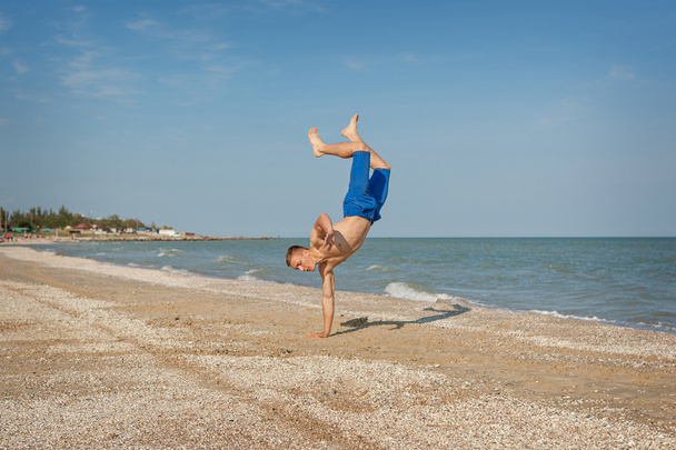 Молодий чоловік стрибає на пляжі
 - Фото, зображення