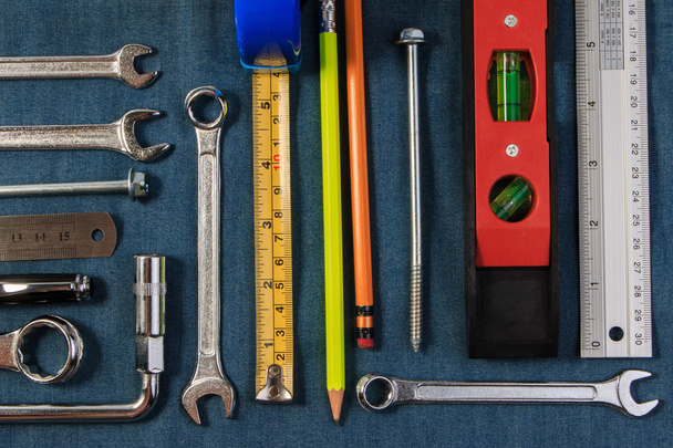 Moersleutel tools op een denim-werknemers. Closeup. - Foto, afbeelding