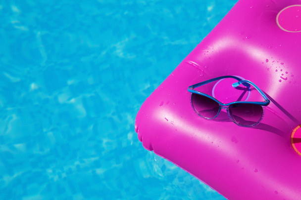 Sunglasses pink air mattress swimming pool. Tropical concept - Foto, afbeelding