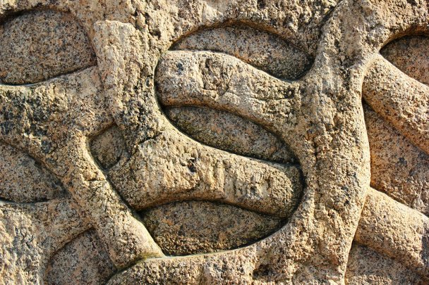 Різьблений кам'яний барельєф з переплетеної лози
 - Фото, зображення