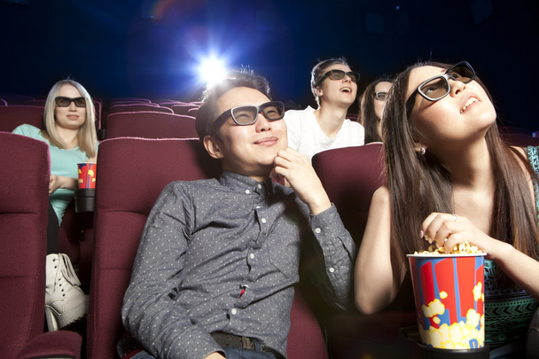 Молодая пара сидит в кинотеатре в 3D очках и смотрит
  - Фото, изображение