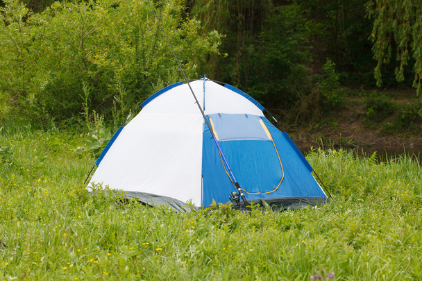Camp tent and fishing rod on outdoor - Foto, imagen