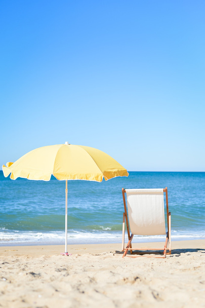 Back View Of Deckchair, Sun Lounger Under Umbrella On Sand Beach. - Foto, imagen