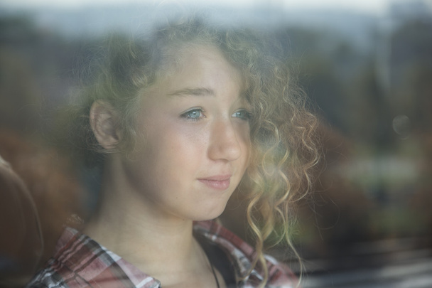 Portret van mooie roodharige meisje achter glas met reflectie - Foto, afbeelding