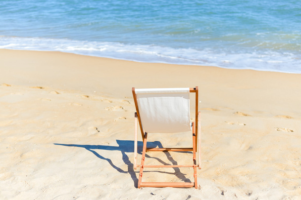 Vista posteriore della sedia a sdraio sulla spiaggia di sabbia
. - Foto, immagini