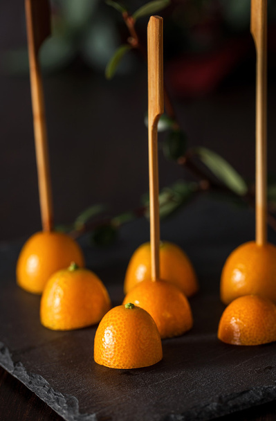 Close-up of several cut tangerines with sticks - Фото, зображення