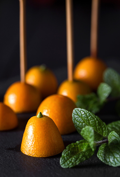 Close-up of several cut tangerines with sticks - Valokuva, kuva