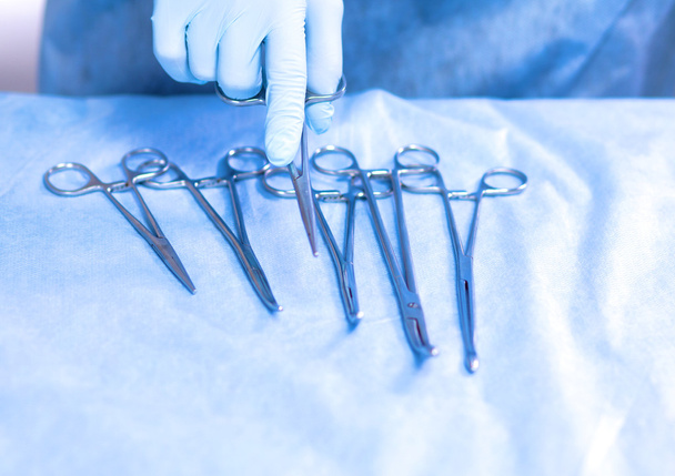 Detailní záběr sterilizovaných chirurgických nástrojů s rukou uchopení nástroje - Fotografie, Obrázek