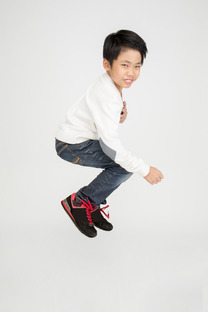 アジアのかわいい男の子が笑顔でジャンプします。 - 写真・画像