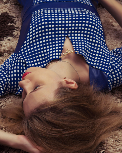 a beautiful young girl lying on the carpet - Фото, зображення