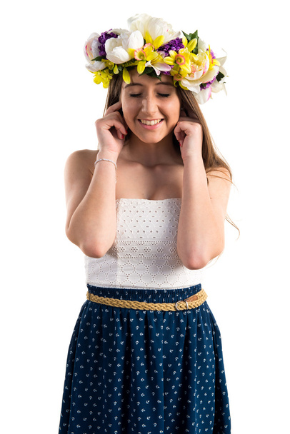 Girl with crown of flowers covering her ears - Fotó, kép