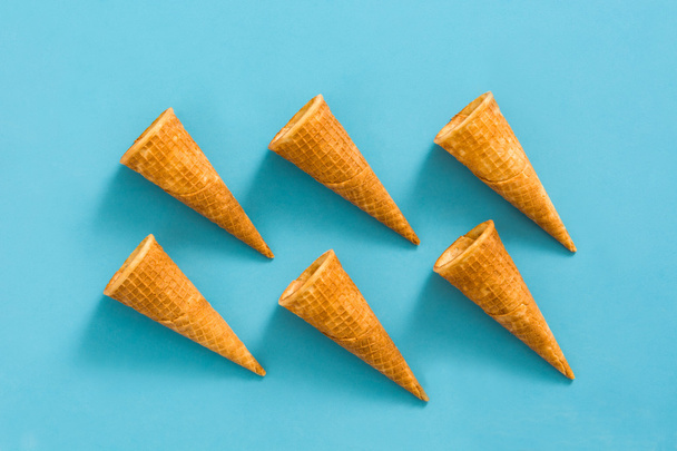Cornets de crème glacée vides sur fond bleu
 - Photo, image