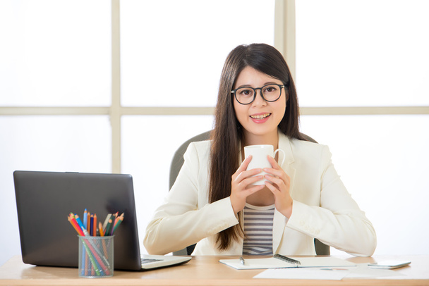 Happy Asian business women smiling and drinking coffee on laptop - Valokuva, kuva