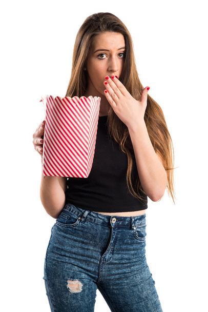 Молода дівчина їсть попкорни
 - Фото, зображення