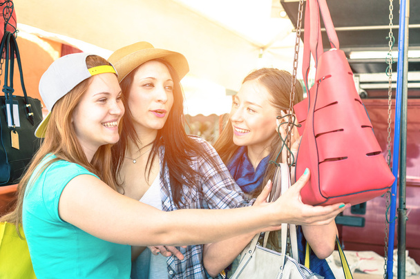 Jovens mulheres bonitas namoradas no mercado de pulgas à procura de bolsas de moda - Melhores amigas se divertindo e fazendo compras na cidade velha - Cruzamento vívido processado tons de cor com halo de sol reforçada
 - Foto, Imagem